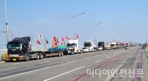 24일 오후 인천신항앞 도로변에 파업 깃발을 걸고 화물차량을 줄지어 주차해 놓고 있다.