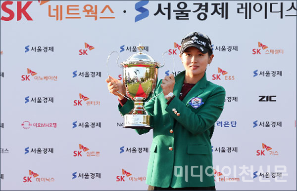 박현경 선수가 우승컵을 들고 포즈를 취하고 있다.